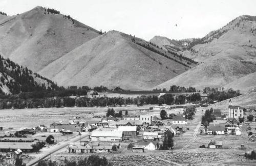 Aerial view of historic Ketchum, Idaho 1930's black and white photo showing a rural town with mountains rising in the background