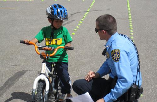Police Officer Helping Child on Bike