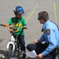 Police Officer Helping Child on Bike