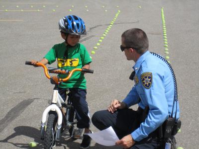 Police Officer Helping Child on Bike